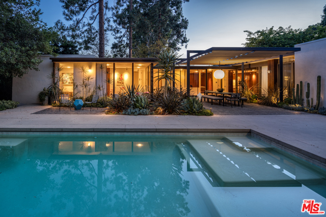 9557 Lime Orchard Road Beverly Hills, California Sophisticated mid-century modern nestled in private and guard-gated enclave of Hidden Valley Estates. Dramatic courtyard entry welcomes one into the Rowan Residence by Robert Skinner (originally photographed in 1964 by Julius Shulman and featured in Taschen's Modernism Rediscovered). The meticulous restoration, led by architect John Bertram with designer Sarah Shetter, is in harmony with the original design, and incorporates Douglas fir furniture-grade custom cabinetry, terrazzo flooring, Calacatta Gold and Salt Marble countertops, LSI museum-quality lighting, redwood tongue and groove interior and exterior siding, all new fixtures, finishes and systems, and chef's kitchen with top-of-the-line appliances. Warm and elegant reimagining of the kitchen, primary suite, and office, with stylishly redone bathrooms and closets throughout the house. Carefully delineated personal spaces offer intimacy and privacy, set off from open floor plan common spaces. Walls of glass throughout create the ideal setting for indoor/outdoor living and entertaining. Beautiful pool, lush greenery, mature trees and gardens designed by Judy Kameon of Elysian Landscapes complete a relaxing and serene atmosphere in a verdant setting. This is a unique opportunity to live in an architectural work of art. Perfect for those seeking an exceptional and private lifestyle.