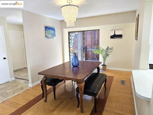 Dining space with light wood finished floors and a chandelier