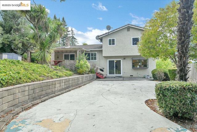 Rear view of house with a patio area and stucco siding