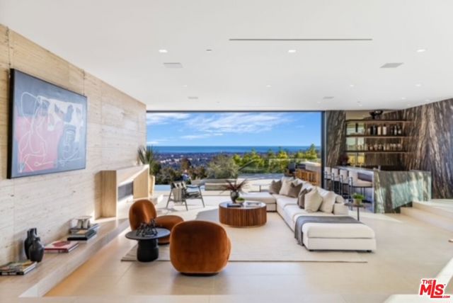 Imagine waking up in your very own wellness retreat - everyday. This newly built, contemporary masterpiece prioritizes health and wellness by integrating proprietary and innovative technology that is not found in any other home currently on the market. At ~10,000+ sq. feet, this magnificent, gated estate is situated on a promontory with a 200+ foot  private driveway overlooking sweeping city, canyon and ocean views to Santa Monica Bay! Immaculately designed with organic finishes including Italian travertine walls, walnut flooring, and imported stone throughout. The indoor and outdoor bars allow for endless entertainment alongside an ocean-facing  infinity pool. Its open concept plan features cantilevered dining room and chef's kitchen with walk-in refrigerator. Upstairs, the primary bedroom opens to a wrap-around rooftop deck adjoining a primary bathroom featuring a unique touch mirror that emits bright light in the morning to enhance energy levels. Downstairs, amenities include a wine cellar, salon, spa, fitness area, private theater, Himalayan salt room, and a 3-car garage. Cutting edge health and wellness elements include: circadian lighting delivered throughout the day to help regulate natural sleep/wake cycles, state of the art air purification & water filtration, posture-supportive flooring, and other comforts. Only moments to Beverly Hills Hotel and Rodeo Drive, this is a must see home!!!