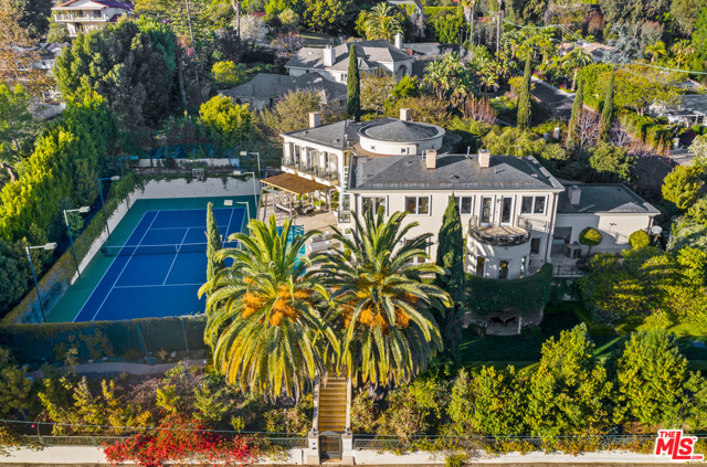 701 N Bonhill Road Los Angeles, California Welcome to this stunning and contemporary Mediterranean home, an entertainer's dream. Set behind gates, this bespoke home provides ample privacy and exclusivity. Access your gated, private abode via the circular motor court, complete with a fountain. Through the intricate front doors, step into the beautiful foyer, and look up to marvel at the 20-foot ceilings, bright windows that span both first and second floors, and wrought iron detail that adorns the circular second-floor balcony. The first floor includes a spacious living room (with library/office attached), chef's kitchen, formal dining, breakfast areas, and direct access to the 3-car garage. A spiral staircase leads upstairs to the primary bedroom and two additional bedrooms, each with its own bathroom, and a large office that can be used as an additional bedroom if desired. On the basement level, find two additional bedrooms with ensuite bathrooms. This level also includes a gym, dry sauna, laundry, and a library/family room that leads out to a side yard. The park-like grounds are perfect for entertaining and can be directly accessed via numerous balconies/entryways. Complete with lush mature landscaping, the 26,000+ square foot lot includes a lap pool, spa, multiple outdoor living areas, tennis court, and a paved path along the perimeter of the estate.