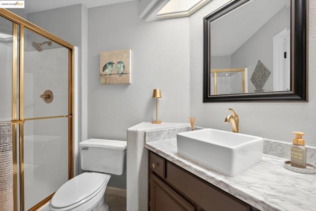 Full bathroom with vanity, a textured wall, and a shower stall