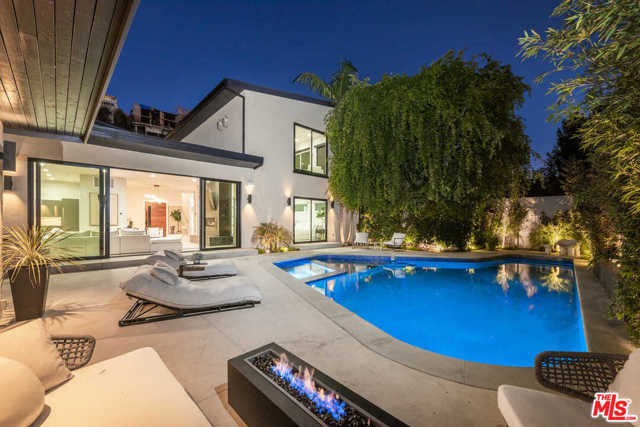 1531 Lindacrest Drive Beverly Hills, California A contemporary architectural oasis, 1531 Lindacrest Drive offers gated living with exquisite design details. Enter the 5-bed, 6-bath home via a tranquil walkway where water trickles from a fountain wall. Upon entrance, indoor and outdoor living collide in the expansive great room; the living area includes a large fireplace and the modern, open kitchen features stainless steel appliances and marble countertops. Glass doors reveal the backyard paradise where lush landscaping surrounds the pool, spa, and patio, beckoning afternoons spent lounging in the sun. Upstairs, the sun-soaked master suite is entirely private, accessed via a separate staircase, and includes its own living room, bar, large windows, a gorgeous en-suite bathroom, luxurious walk-in closet, and ocean views. A floating walkway leads to the media room with a projector, surround sound, a bar, and seating areas. A guest home offers a private side entrance. Welcome to a modern Beverly Hills lifestyle offering beauty and ease.