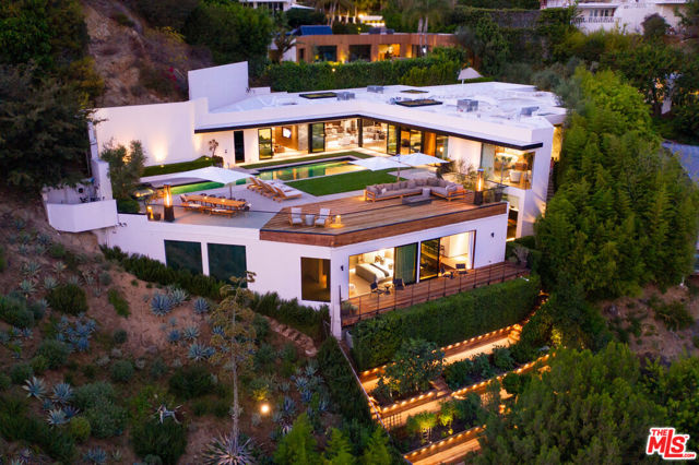 1877 Rising Glen Road Los Angeles, California ONE877. This contemporary masterpiece is one of the greatest architectural gems on the market today. Perched on an impeccable promontory in the bird streets, this 8,339 SQFT home was recently updated and reimagined into the flawless property you see today featuring design by the renowned Kathleen and Tommy Clements. A formal entry leads to a natural light-filled open concept living space. The kitchen, library, dining, and living areas open to a lavish outdoor area and offer unobstructed, sweeping views of the city. A grand fireplace, floating walnut shelves, and skylights throughout are the essence of warm, modern luxury. The gourmet kitchen features top of the line Miele appliances, a WineMate cooling system, and robust skylight. The sumptuous master suite offers floor to ceiling windows framing the beautiful view, a fireplace, and luxurious closet and bathroom with a Mr. Steam shower and Boffi fixtures. Completing the primary level's interior are two additional en-suite bedrooms. The expansive outdoor area offers an oversized pool, deck, and lush grass that takes you down to an additional level with a guest suite and wrap-around deck offering the same magnificent views. Completing the level is a bar, home theater, and gym. Down some steps is a 1,000+SQFT edible garden with a lit deck for even more outdoor entertaining space. This one of a kind property is truly a trophy of the Bird Streets and not one to be missed.