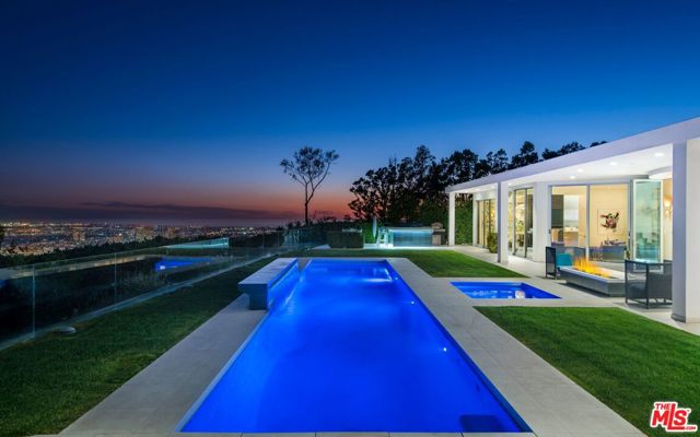 1790 Carla Beverly Hills, California Situated on a prime city view rim lot in prestigious Trousdale Estates rests this distinguished, newly remodeled mid-century contemporary estate with breathtaking vistas from downtown to the Pacific. Behind the private gates, be greeted by a meticulously landscaped motor court complimented by large fire features and hedged private driveway for a grand welcome to the 4 bed, 6 full baths, 2 half baths, 6,472 square foot abode. The oversized living spaces are bathed in natural light, with walls of windows opening to expansive manicured gardens with incredible jetliner views. This home offers the ultimate indoor/outdoor living. Luxurious amenities include a theater, chefs kitchen, office, wine cellar, wet bar, and the finest finishes throughout. The master is embellished with floor to ceiling windows, vast walk-in his and her closets, and spa-like bathrooms. Retreat to the resort-style backyard entertainment oasis with patio, lounge area, fire pit, outdoor bbq area & pool and spa. An artful lifestyle experience meticulously curated with iconic Beverly Hills sophistication.