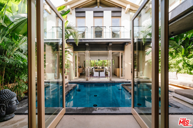 918 Milwood Avenue Venice, California The Venice Tulum House, a masterful architectural home completed in 2019. Gated and private, surrounded by lush tropical palm trees, you'll feel transported to an exclusive luxury resort in Tulum. Let a holistic sense of well-being wash over you, as the homes symmetry and balance create a harmonious space. Built for indoor/outdoor living, the ground floor features an open floor plan with 3 sets of pivot doors that open to the front patio and inner courtyard with a heated saltwater pool and spa. Upstairs, all 3 sun-drenched bedrooms are en-suite with bathrooms featuring tumbled Turkish travertine counters and rain showers. Additional highlights include a phenomenal skywalk, den/media lounge, office (or potential 4th bedroom), laundry room, 2-car garage plus gated driveway parking for 2 cars, and bathroom with outside access, perfect for showering off after the beach. Located on one of the best streets in Venice, only blocks from dining/shopping on Abbot Kinney and Lincoln.
