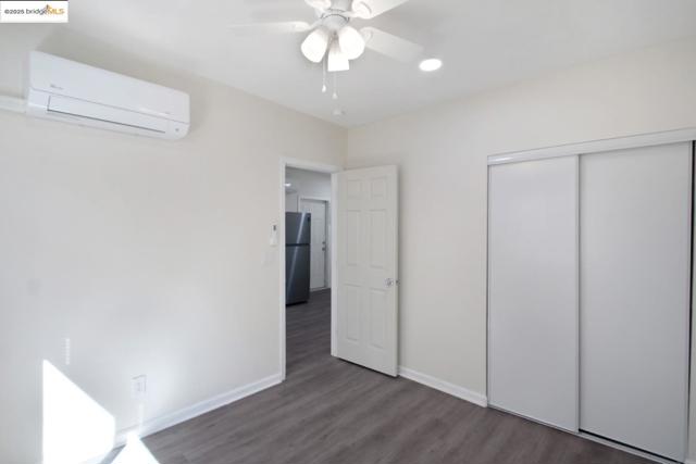 Bedroom 2 with a wall mounted mini-split HVAC, dark wood-style floors, a ceiling fan, and recessed lighting