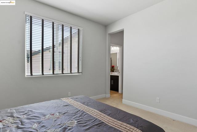 Bedroom featuring baseboards and light carpet