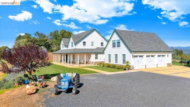 view of front of home with a porch, concrete driveway, a front yard, and a shingled roof
