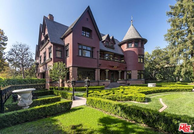No expense was spared in the meticulous restoration of this historic property. Built in the 1890's by Isaac Newton Van Nuys, this 3-story Victorian was moved to its current location in Windsor Square by his son J. Benton Van Nuys in 1915. The main residence offers 12,565 square feet: 11 Bedrooms and 8.5 baths. There is also a 2 bedroom 1 bathroom carriage house atop a large garage with exterior turntable. 7 fireplaces. Gated and secure, all is set back on an expansive 26,966 square feet lot. The traditional floor plan offers a grand salon that seamlessly flows to the library/den and formal living room/sitting room. The dining room is lined with linen-fold paneling & leaded, stained glass windows and is connected to the chef-quality kitchen that has been fully renovated in keeping with the home's original style. The hidden bar with hand carved walls has a secret door leading to the showstopping pool, spa and manicured gardens. There are 5 bedrooms on the second floor, including multiple suites and a well appointed and spacious walk in closet.The top floor provides an especially unique living space that doubles as a theater with bar/kitchenette. The stage is complete with original footlights, and a dramatic turret side room. There are 3 additional bedrooms and 2 bathrooms on the upper level. Systems thoroughly updated and/or replaced. Multi-zone HVAC was painstakingly installed without disturbing intricate original wood and plaster work.This is a rare opportunity to own one of the more magical estates in the area.