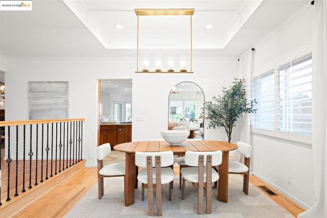 Dining area featuring light wood-style floors, recessed lighting, a raised ceiling, and a chandelier