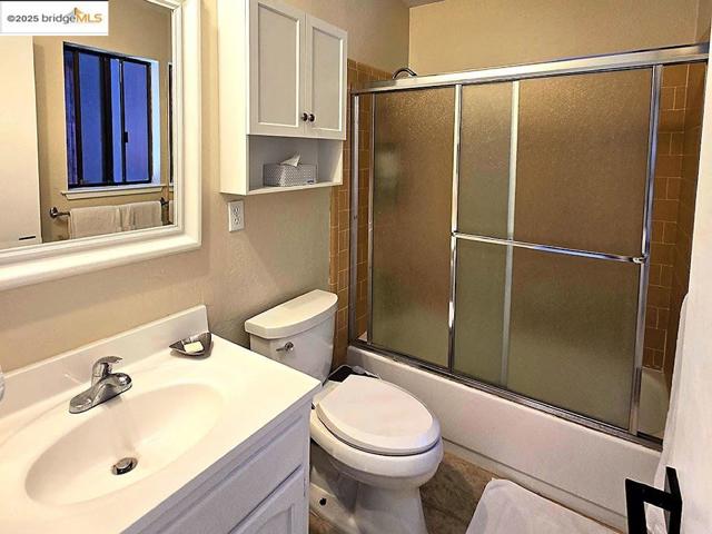 Bathroom featuring shower / bath combination with glass door and vanity