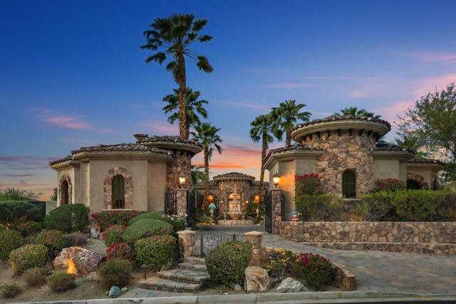 This classic Mediterranean Villa  with stunning panoramic views was  built on a premier lot in Ironwood Country Club in 2007.  The private remote controlled gate opens to a beautiful courtyard with a 3 tiered  fountain. Tall double doors lead you into the gracious and spacious living area. Vaulted  & beamed  ceilings are throughout the property. There  are 4 fireplaces: 1 in the living room, 1  in the casita and 2 outdoors. A wall of Fleetwood  glass  sliders disappears into the wall  & opens to the wrap around  covered patio,  extending your living space.  Wonderful entertaining & private enjoyment of the desert life style is easy with the outdoor fireplace, pool &  hot tub and  waterfall features w  stunning,  panoramic views of the valley, city lights, mountains, sunrise and moon rises, and sunsets.. Eight foot solid core doors are throughout, and double doors lead to the many outside sitting areas.  There are 3 bedrooms and a den in the main house with 3 baths plus powder room.   The spacious den could be converted easily to another bedroom & opens to  its own courtyard with outdoor fireplace. The private casita has  2 bedrooms, 2 baths and a sitting area with fireplace. The home has a classic European elegance with Travertine  &  carpeted floors, smooth walls, large windows & great light, A large formal dining room is close to the gourmet kitchen with its Wolf double ovens, Viking range, kitchen island,  Bosch dishwasher and walk in pantry.