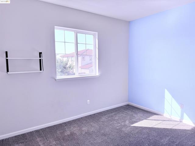 Carpeted empty room featuring baseboards