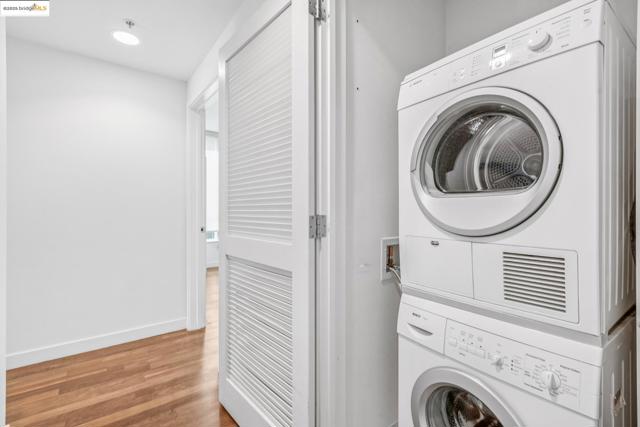 Laundry area featuring estacked washer and dryer, light wood-style flooring, and recessed lighting