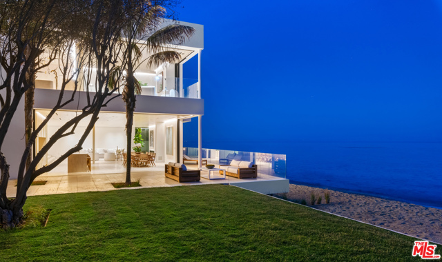 27234 Pacific Coast Highway Malibu, California Luxurious architectural on two separate legal parcels on private road with 130 feet of beach frontage and one-of-a-kind coastline/island/ocean views. Sleek design by Chad Oppenheim for indoor-outdoor living and entertaining features Venetian plaster, rift sawn white oak, huge vanishing pocket doors, Navona travertine floors. Gated, very private, three levels with elevator and gorgeous spiral staircase. Landscaped courtyard entrance. Open main floor living/dining/kitchen with high ceilings, wraparound glass walls that open seamlessly to oceanfront deck and patio. Living area has fireplace, gallery walls, two large seating areas, one open to ocean, the other open to an outdoor garden living room with fireplace and fountain. Beachfront deck has additional seating and ample room for entertaining and al fresco dining. Two kitchens include long island, bar seating, beautiful oak cabinets, top-grade appliances. Upper floor has large indoor/outdoor living room with glass ceiling and wood beams, plus four en-suite ocean-view bedrooms including two owners' suites. Bottom floor has temperature-controlled wine storage, media room, laundry room. Room for a guesthouse (under construction) 2nd residence, & oceanfront pool next to an expansive lawn and 100-year-old Olive Grove. Two-car garage, guest parking for 14 cars, beautiful landscaping, many smart-home features.