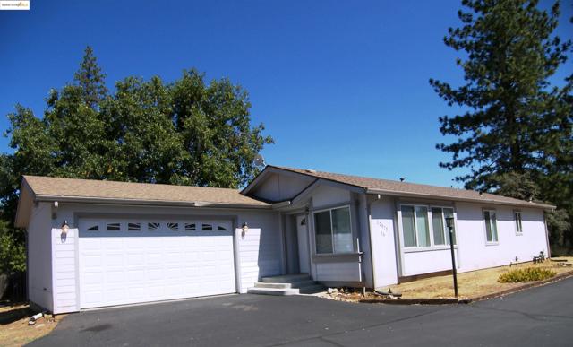Ranch-style home with asphalt driveway, a shingled roof, and an attached garage