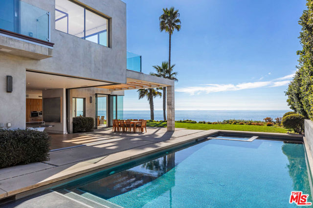 This stunning beachfront Point Dume estate merges outstanding architecture by Doug Burdge and a coveted bluff frontage location overlooking Zuma/Westward beach. Combined with a guest home, the property features 7 beds, 9 baths, and 10,180 SF of living space on an acre, poised for a life of luxury and ease. Beautiful views are the backdrop for an extraordinary life. Indoor and outdoor living collide gracefully with walls of glass, two view decks, and a front courtyard sitting area. Inside, the main two-story residence imbues a coastal modern aesthetic with warmth and livability. The great room includes wide pocket doors that open to a 50-foot pool/spa. An office, laundry room, full bar, outdoor shower, gym, wine cellar, and four-car garage add ease, as well as a Savant Pro8 home automation system and 12 security cameras. Here, life is truly a vacation, presenting tranquil days and enchanting evenings all intimately connected to the sea.