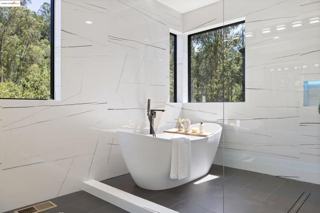 Bathroom featuring a soaking tub, tile walls, and tile patterned flooring