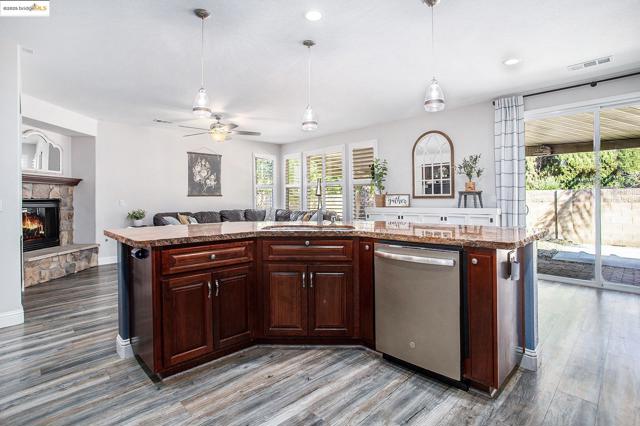 Kitchen featuring a dishwasher, an island with a sink, and an open floor plan