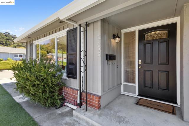 Doorway to property featuring board and batten siding, brick siding, and a porch