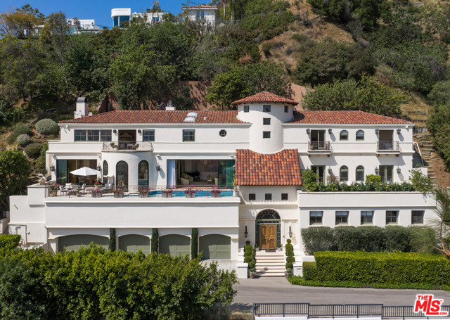 1675 Woods Drive Los Angeles, California Set above the Sunset Strip and Chateau Marmont, this exquisite Italian Villa sited on a double lot with mind blowing views of the city. The recently renovated home features a dramatic two-story entry with a sweeping staircase and elevator, impressive 12 ft ceilings inviting natural light, and floor-to-ceiling Euroline doors/windows perfectly framing the elegant terrace with a mosaic pool and spa overlooking the city below. The extraordinary details throughout this gorgeous home include baccarat fixtures, custom lighting, mosaic tiles, French limestone, hardwood floors, Sonos, and state-of-the-art appliances. The prestigious primary suite boasts a formal entry with 16 ft ceilings, Parquet floors, cozy fireplace, a large bathroom with steam shower, tub, sauna, two large walk-in closets, laundry room and two terraces capturing breathtaking sunrises to city lights. 3 additional large suites create multiple living zones throughout the home as well as a media room and office with a private terrace and fountain. 5-car garage fit for an auto enthusiast. Ideally located on a quiet cul-de-sac, this re-imagined estate offers incredible scale, the finest materials, and unobstructed panoramic views from nearly every room!