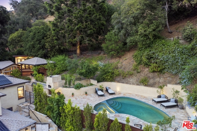 2024 Benedict Canyon Drive Beverly Hills, California Privacy and serenity surround you in this beautifully updated 4 bedrooms, 3.5 bath home, set back from the street and tucked away on a secluded lot surrounded by lush landscaping. With its resort style salt-water pool & spa, multiple lounging areas, separate grassy yard, romantic canopied outdoor dining, fire-pit, outdoor kitchen, vegetable garden and pizza oven imported from Italy, you'll feel in vacation mode all year long. On the main level: a formal living room with fireplace opens to the dining room and the flow continues into the impeccably designed kitchen, oversized center island and lovely breakfast area with a second fireplace. This level is completed by 2 bedrooms separated by a full bath and a light filled primary bedroom suite leading to a stunning bath with heated floor and a huge closet. On the lower level: a large 4th bedroom with separate entrance, currently set-up as a den, a full bath, a wine cellar for approx. 750 bottles and several storage areas. A detached studio with peaceful canyon views is ideal as a separate office or gym. Entertaining is a breeze with plenty of room to park on site. The property has been updated with solar panels, a back-up generator, tankless water heaters and an EV charger. Located just minutes away from Beverly Hills and its world-famous shopping, dining, and entertainment!
