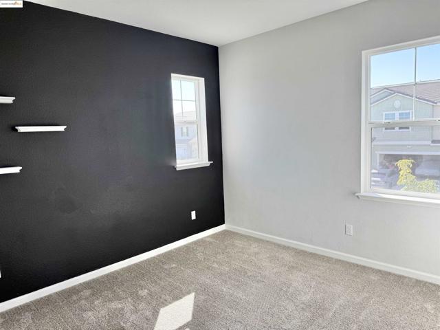 Unfurnished room with baseboards and carpet