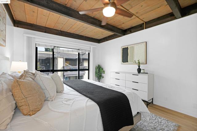 Bedroom featuring a wooden ceiling with exposed beams, ceiling fan, and light wood finished floors