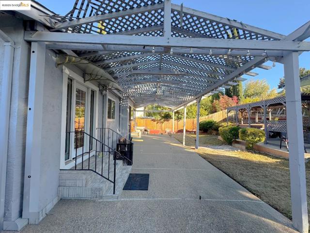 Fenced backyard featuring a pergola and a patio