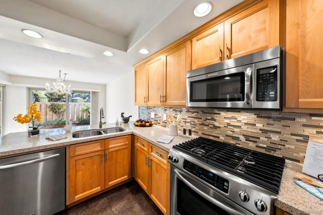 Kitchen offers stunning glass backsplash, gas range and open to dining room