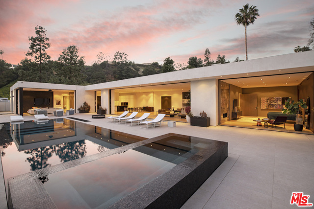 1220 Loma Vista Drive Beverly Hills, California Extraordinary Contemporary Masterpiece with views located on a large apx. 24,000 sq.ft. lot in prime Trousdale Estates. Flawlessly designed & crafted by Schmidt Architecture with the highest quality materials & finest details. The architecture of this magnificent home delivers clean lines with disappearing walls of glass that seamlessly integrate the interior & exterior spaces & reveal beautiful city to ocean views. Gated with motorcourt & 3-car garage. Formal foyer leads into the living room, dining area, & kitchen that flow together for a magnificent great room. The kitchen features Poliform cabinets & professional Miele appliances. Family room converts into an automated home theater. Exceptional master suite with fireplace, luxurious bath, & yoga studio or gym, all opening to a private patio garden with firepit & daybed. 3 addl bdrm suites. Control4 smart home system. The backyard allows great space for entertaining featuring patios, firepit, BBQ, zero edge saltwater pool, & spa.