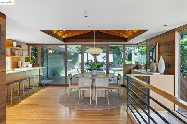 Dining area with a wall of windows and light wood-type flooring