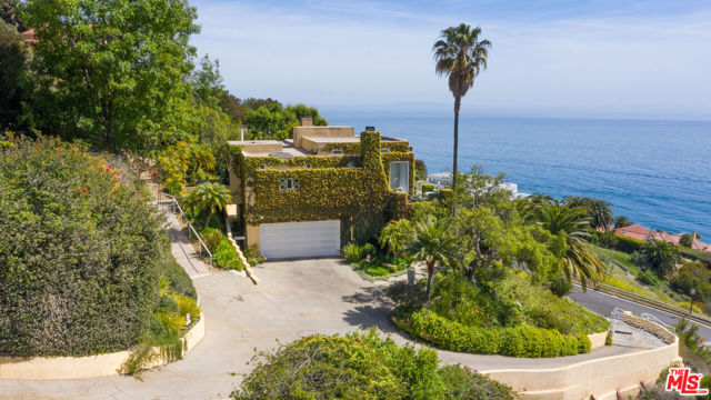 An architectural home with 180-degree ocean views located in the desirable La Costa area of Malibu. The vine-covered exterior and entryway beautifully blend the landscaping and design of the home creating a coastal European experience. Inside, the grand scale of the glass doors and clerestory windows coupled with the height and volume of the great room invitingly frame the head-on expansive ocean views. Retractable awnings stretch over the long outdoor patio and offer covered ocean-view seating above the sun-drenched gardens below. There is a chef's kitchen with a center island and breakfast bar that open seamlessly to the high-ceilinged great room. Enjoy the soothing sound of the surf from the impressive primary bedroom, which opens to a generous patio with panoramic ocean views. With views from every room, this custom home is a special, seaside treasure that rarely comes along. Celebrate the Malibu lifestyle with beach and tennis court rights at La Costa Beach Club, limited to only the homes in this area, where you can surf, swim, picnic on the sandy beach complete with volleyball and children's play structure, and party in the trellis covered picnic area equipped with heater lamps, commercial kitchen and BBQ's. Located on the easterly end of Malibu, with easy access to Duke's Restaurant, Moonshadows, or Maestros for oceanfront dining, and a short drive to Santa Monica or central Malibu.