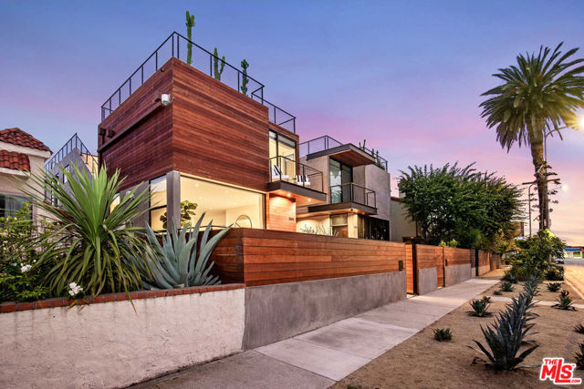 2331 Abbot Kinney Boulevard Venice, California Ideally located on Abbot Kinney this newly constructed, contemporary home (w/elevator) conceived by Electric/Bowery features all the specialty details of a custom designer home. The main floor opens to a chefs kitchen with rich custom cabinetry, wine refrigerator & sleek marble countertops, extending into the formal living room w/fireplace, large outdoor deck & additional en-suite guest bed/office. Chic, black cable stairs lead to the upstairs living room which seamlessly connects to the spacious primary suite w/balcony, fireplace & steam, 2 en-suite bedrooms & laundry. The lower level includes a large sitting den, en-suite guest bed & 2-car garage w/gated driveway that also functions as a separate entrance on the adjacent street w/add'l parking. The rooftop deck is spectacular, overlooking Venice with views to the ocean along w/outdoor BBQ. Surrounded by wood decking & California landscaping, this pristine home is walking distance from prime Venice dining & illustrious LA beaches.