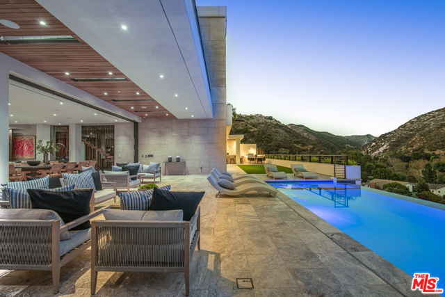 2447 Arbutus Drive Los Angeles, California This stunning, warm contemporary, brand new construction is one of the most spectacular properties to come to the market in Brentwood. This home offers extraordinary unobstructed views of the San Gabriel Mountains and City. Enter through the homes massive front pivot door to an open floor plan & floor-to-ceiling windows providing an abundance of natural light throughout. Featuring a chefs kitchen, open living & family room, custom gym, theater w/ built-in bar, wine cellar, sauna, office & elevator are just a few of the amazing amenities. The lower level opens to a large covered patio, suitable for parties and access to the vegetable garden and fruit trees. The master suite reveals stunning dual master closets and bathrooms & freestanding bathtub that opens to the balcony with incredible views. The backyard features a zero-edge pool & spa, outdoor bar, & BBQ. Enjoy your own personal oasis in this extraordinary home of modern luxury & timeless style.