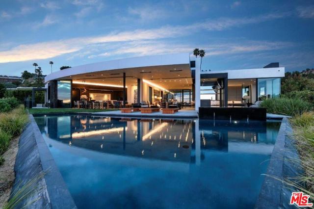 514 CHALETTE Drive Beverly Hills, California A spectacular hillside glass-walled sanctuary by design icon Mark Rios with Trousdale Estates most explosive panoramic city to ocean views. Interiors by Dusenbury Design, this modern organic masterpiece provides the most captivating entertainment features. Behind the privacy of a 13-ft architectural wall, the 12,456-sf, 6-beds, 11-baths estate boasts a 15-ft waterfall in the front court cascading into a lower-level reflecting pool & a 2100-sf subterranean garage. Elegant, clean lines reflecting mid-century modern sophistication meet luxurious stone, wood & marble finishes. Floor-to-ceiling doors & elegant open concept fill every inch of the main living spaces with natural light and unobstructed views. Chefs kitchen, breakfast bar, formal & alfresco dining. Outdoor entertainment features a firepit lounge with a bar and a lush terrace with an expansive pool/spa soaring over the skyline. Lower-level entertainment oasis features a stunning blue velvet lounge with a marble bar, an oversized glass wine cellar & a theater with matching palette. Lavish 1,600-sqft primary suite features dual bathrooms with a tranquil tub overlooking the 360 vista. Additional amenities include gym, massage, elevator, beauty salon, en-suite guest rooms & staff quarters. Make your mark among the most discerning elite with this legendary home.