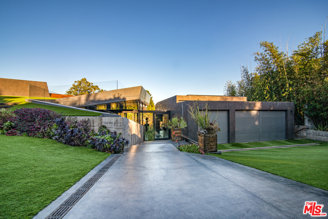 314 N Barrington Avenue Los Angeles, California An exquisitely built architectural masterpiece by Eric Rosen Architects situated in the heart of Brentwood is all about asymmetrical lines. Hidden behind mature landscaping, hedges and gates, the ultra-modern sleek design of simple geometry is thoughtfully done to create comfortable and modern living spaces. The front of the home is almost entirely covered with grass while the backyard is equipped with a pool and a view of the surrounding landscape including the Getty Center. The sliding doors open wide to create a seamless indoor-outdoor flow with an abundance of cascading, light-filled living spaces built into the hillside. Environmentally-conscious and energy efficient design elements were incorporated into the home, including a state-of-the-art geothermal heating & cooling system, a solar powered ion pool, honeycomb radiant floors, and tankless on-demand water heating. With superior hand-selected materials and cutting edge amenities this estate is truly one-of-a-kind.