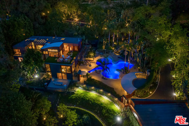 12835 Mulholland Drive Beverly Hills, California Ultra-secure & private, steeped in Hollywood history, this architectural compound sits behind gates on 2.38 acres on the famed Mulholland corridor. Top of the world location - less than 10 minutes from the Polo Lounge; the new Studio City Erewhon & best private schools in the city, the 405 & the 101. Spectacular city views without any sounds of the city. True indoor/outdoor living w/ 30 ft windows & doors that showcase natural elements while living & entertaining amidst every modern amenity. The main structure designed by renowned AIA architect, Alex Istanbullu boasts a chefs kitchen w/ state-of-the-art appliances; Bel Air Circuit Screening Room w/ a soda machine; expansive entertaining living room & dining area; subterranean climate-controlled wine room; a full floor master suite w/ a wood burning fireplace, gym, steam shower, sauna & 2 decks. There are 4 addt'l bdrms, a tv area, office & playroom. The Heptica shaped leaf swimming pool built in the 1940s features an underwater viewing room. The outdoor area has a full kitchen, 2 outdoor bthrms, wood burning fireplace & an oversized fire pit. The property has 2 additional guest areas; whimsical treehouses; an art cabin; a flat grassed play space w/ addt'l parking. An oasis in the city. A transportive property that is magical at night & feels a world away from Beverly Hills/Los Angeles.