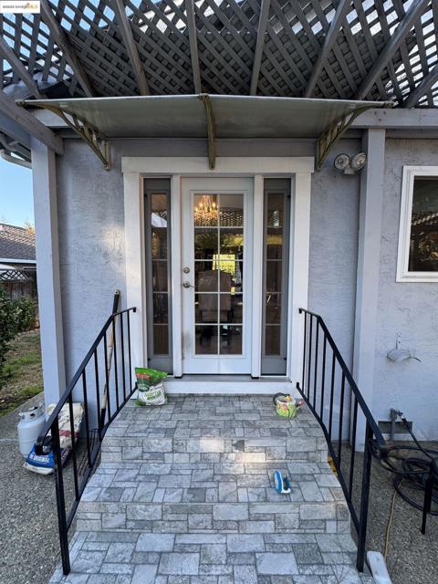 Entrance to property with a patio, stucco siding, and a pergola