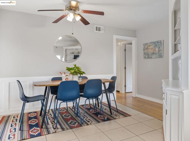 Dining room with light tile patterned flooring and a ceiling fan