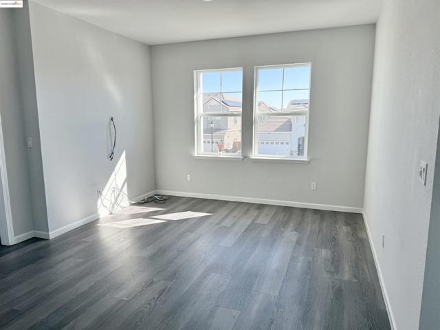 Unfurnished room featuring dark wood-type flooring and baseboards