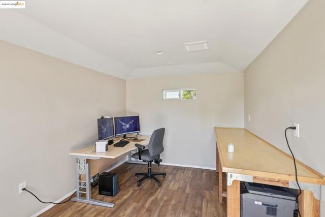 Office space with wood finished floors and vaulted ceiling