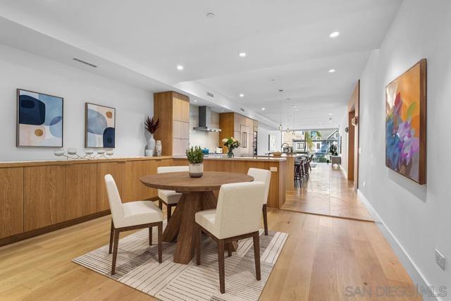 Virtually staged dining area with Shinnoki sustainable custom wood cabinetry and luxury hardwood flooring.