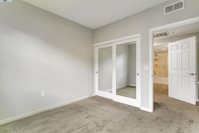 second bedroom with mirror closet doors