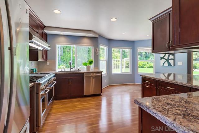 Custom cabinetry and beautiful laminate wood floors + pool view!