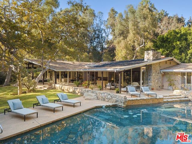 1100 RIVAS CANYON Road Pacific Palisades, California A rare and exceptional example of untouched mid-century modern style designed by critically acclaimed Architect William R. Stephenson AIA & built by Jack Straus. Stephenson was best known for designing the homes of several celebrities of Hollywood's Golden Age including the Pacific Palisades home of Ronald & Nancy Reagan. Located on the sought after & private road named Rivas Canyon right off Sunset Boulevard in the heart of Pacific Palisades area of Los Angeles. The house has 7 bedrooms, 5 baths, including the master wing with 2 bedrooms and an eastern wing with 4 guest bedrooms. There is an additional staff room with living area, bedroom & bath. Original 1960's condition, well maintained and a dream project for a decorators or designer. 4+ acres zoned for equestrian use with approximately 1.5 acres flat and directly connected via horse trails to Will Rogers Park. Interior photos with furniture are virtually staged.