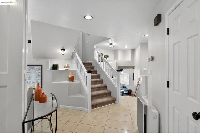 Staircase with tile patterned flooring and recessed lighting