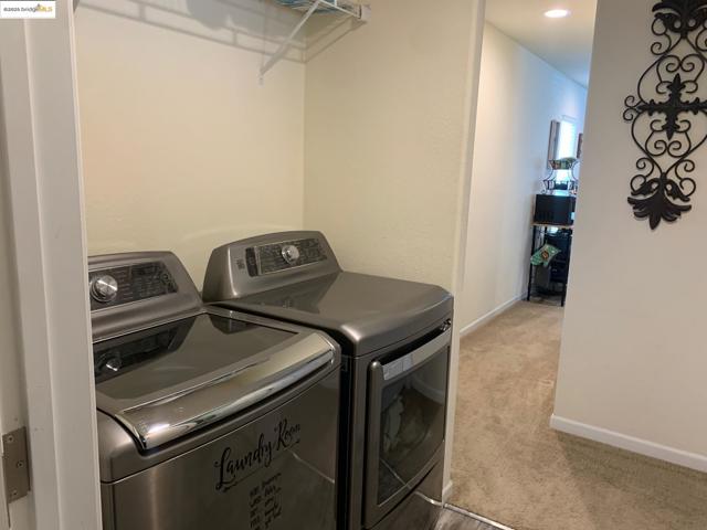 Laundry area featuring washing machine and dryer and carpet floors