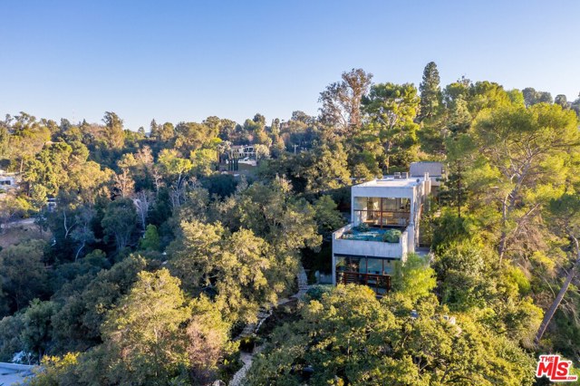 3201 Coldwater Canyon Lane Beverly Hills, California As featured in Architectural Digest, this modern estate sits on approximately 2 acres accessed via a private gated drive and nestled in the most breathtaking setting. Mature trees and an unbuilt canyon surround 3 modern structures overlooking the entire valley. The main home features dramatic 16' ceilings, expansive windows offering beautiful natural light, and views from every room.A separate structure contains a large 3-car garage with private studio/guest suite above, located adjacent to a large motor court. Follow the path down to find carefully placed guest/pool house with its own parking adjacent to a dramatic pool and spa. Sophisticated and restrained design hidden in the most natural and tranquil surroundings inspire a healthy, creative and serene lifestyle.